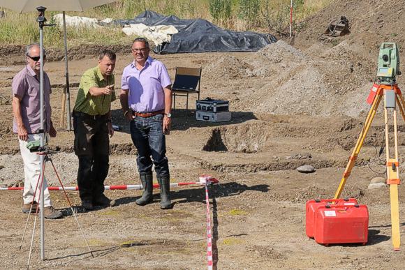 Ingenieur Dieter Dziuba, Kreisarch&auml;ologe Dr. J&uuml;rgen Hald und B&uuml;rgermeister Hans-Peter Lehmann (von links) bei der Besichtigung der arch&auml;ologischen Grabungen im neuen Baugebiet „Dohlen“ in Ehingen. Die Fundamentgruben eines &uuml;ber 100 m&sup2; gro&szlig;en pr&auml;historischen Hauses zeichnen sich als dunkle Verf&auml;rbungen im Untergrund ab. (Bild: Landratsamt Konstanz, Kreisarch&auml;ologie, Foto: J&uuml;rgen Ehrle).