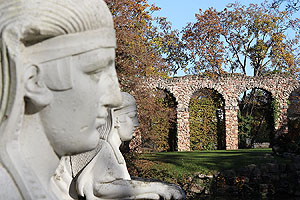 Sphingen am Tempel der Waldbotanik mit den Bögen des Auqädukts im Hintergrund