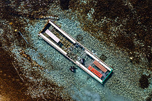 Blick auf den eingehausten Einbaum mit Forschungstauchern aus der Luft